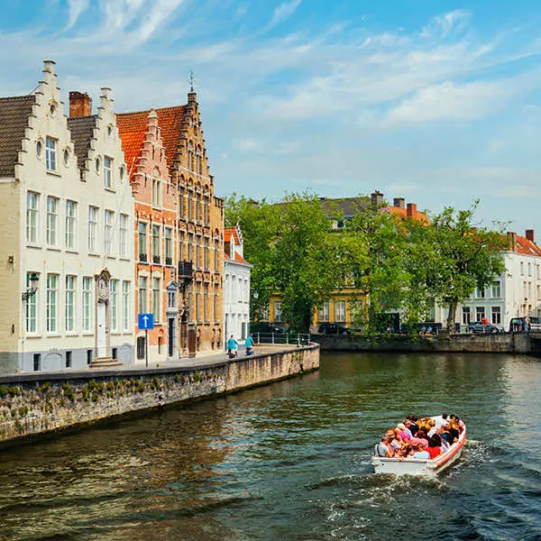 Trapgevels langs een Brugse rei met een rondvaartboot